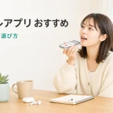 ボイトレアプリおすすめ｜無料・有料の選び方のヒーロー画像。明るい部屋でスマートフォンに向かって発声練習をする大人初心者